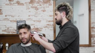 Adam Kuaför kesim saç kesme makinesi kuaför dükkanında erkek istemcinin. Saç şekillendirme işlemi. Ağır çekim yakın çekim