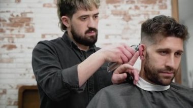 Adam Kuaför kesim saç kesme makinesi kuaför dükkanında erkek istemcinin. Saç şekillendirme işlemi. Ağır çekim yakın çekim