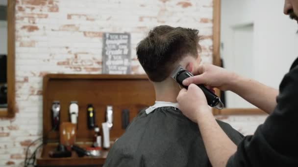 Man Frisör klippa hår av manlig klient med clipper på frisör. Hårstyling processen. Slow motion närbild — Stockvideo