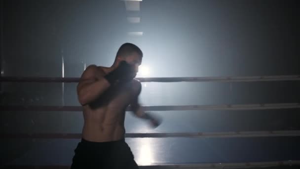 Profesionale masculin kickboxer formare singur în interior în sala de gimnastică modernă în interiorul unui inel de box. — Videoclip de stoc