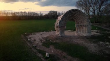 San Miguel de Mazarreros 'un alacakaranlıktaki yıkık ortaçağ kemerinin Olmillos de Sasamon' daki hava manzarası. Burgos, İspanya.