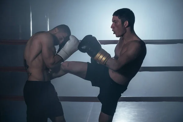 Two shirtless muscular man fighting Kick boxing combat in boxing ring. — Stock Photo, Image