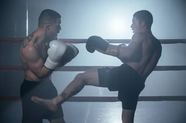 Two shirtless muscular man fighting Kick boxing combat in boxing ring. — Fotografia de Stock