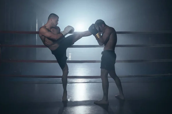 Two shirtless muscular man fighting Kick boxing combat in boxing ring. — Fotografia de Stock