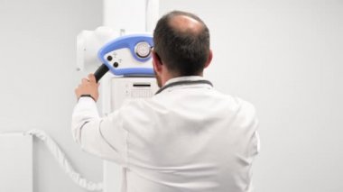 Doktor radyoloji bölümünde röntgen cihazı kullanıyor.