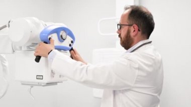 Doktor radyoloji bölümünde röntgen cihazı kullanıyor.