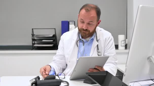 Läkaren ser orolig en röntgenbild på digital tablett, kontrollera resultaten av en läkarundersökning. — Stockvideo