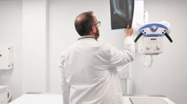Doktor radyoloji odasındaki hastanın röntgenini inceledi..