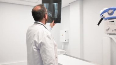 Doktor radyoloji odasındaki hastanın röntgenini inceledi..