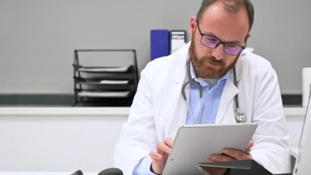 Manlig läkare med vit rock och stetoskop med hjälp av tablett, nätverksanslutning i sjukhusrum, Medicinsk teknik nätverk koncept — Stockvideo