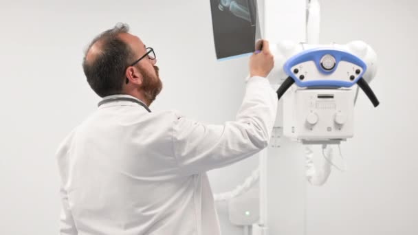 Doktor radyoloji odasındaki hastanın röntgenini inceledi.. — Stok video