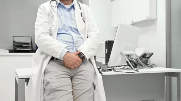 Retrato del médico confiado cruzando las manos y sonriendo a la cámara. — Vídeos de Stock