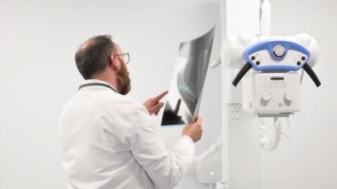 Doktor radyoloji odasındaki hastanın röntgenini inceledi..