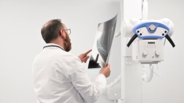 Doctor examine a film x-ray of a patient at radiology room. — Vídeo de stock