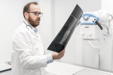Doktor radyoloji odasındaki hastanın röntgenini inceledi..