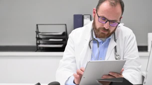 Mužský lékař s bílým kabátem a stetoskopem pomocí tabletu, síťové připojení v nemocničním pokoji, koncept sítě lékařské techniky — Stock video