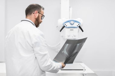 Doktor radyoloji odasındaki hastanın röntgenini inceledi..