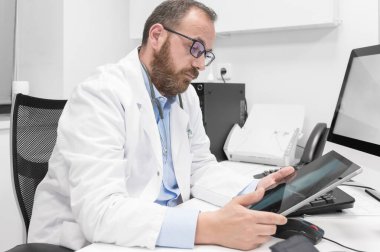 Doktor işte tablet bilgisayarını kullanıyor.