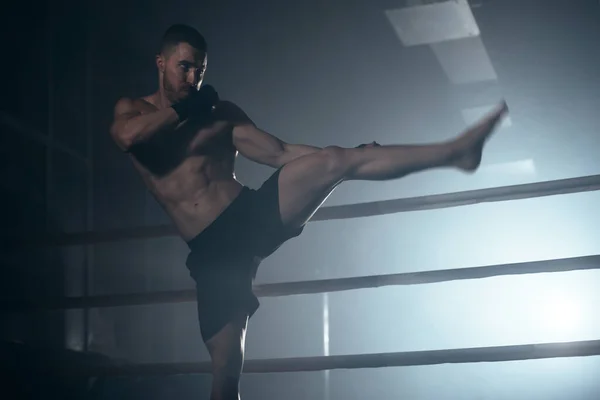 Lutador de MMA muscular praticando chute, conceito de clube de luta. — Fotografia de Stock