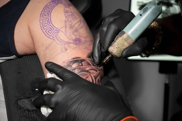 Vista de cerca macro del proceso de tatuaje. Master hace líneas de contorno con su máquina de revestimiento profesional hecha a mano. — Foto de Stock