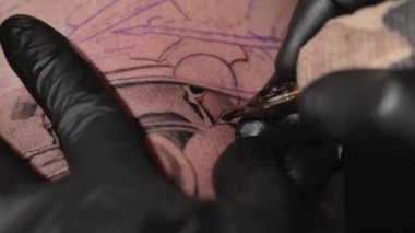 Dövme işleminin makro görünümünü kapat. Usta, el yapımı profesyonel yolcu gemisi ile hatlar çiziyor..