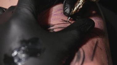 Dövme işleminin makro görünümünü kapat. Usta, el yapımı profesyonel yolcu gemisi ile hatlar çiziyor..