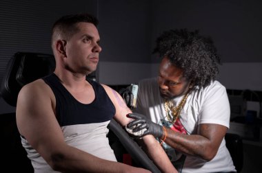 Dövme stüdyosunda vücut sanatı yaratan bir dövmecinin sinematik çekimi.