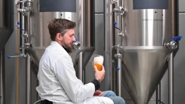 Brouwer draagt witte vacht controle proces van bier gisting tijdens het werken in moderne bierfabriek. — Stockvideo