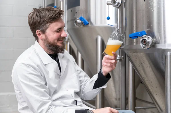 现代啤酒厂啤酒发酵过程中穿白外套的酿造机. — 图库照片