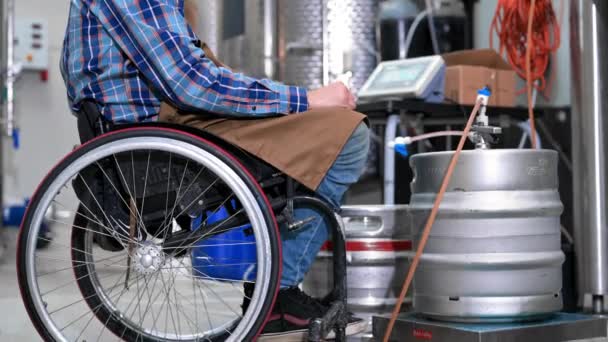 Man in rolstoel aan het werk in brouwerij fabriek. — Stockvideo