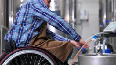 Person with disability who uses a wheelchair working at craft beer factory.