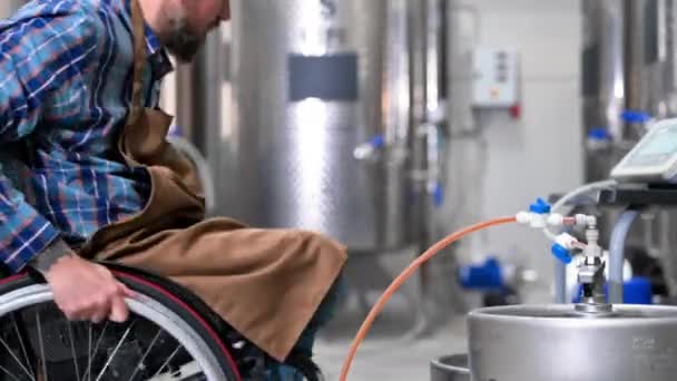 Man in rolstoel aan het werk in brouwerij fabriek. — Stockvideo