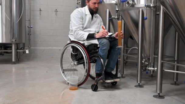 Person with disability who uses a wheelchair working at craft beer factory. — Stockvideo