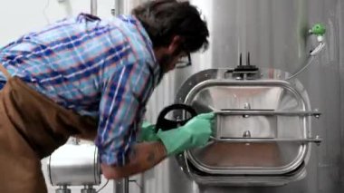 Bira fabrikasında çalışan bir adam içki imalathanesini kapatıyor.