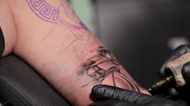 Dövme işleminin makro görünümünü kapat. Usta, el yapımı profesyonel yolcu gemisi ile hatlar çiziyor..