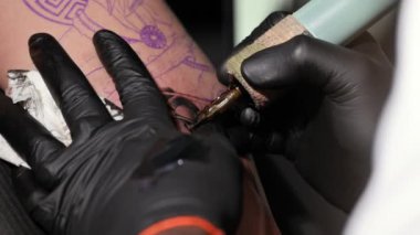 Dövme işleminin makro görünümünü kapat. Usta, el yapımı profesyonel yolcu gemisi ile hatlar çiziyor..