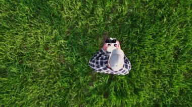 Buğday tarlası verimliliğini kontrol etmek için dron kullanan bir çiftçinin hava görüntüsü. Tarım sektöründe modern teknolojilerin kullanımı