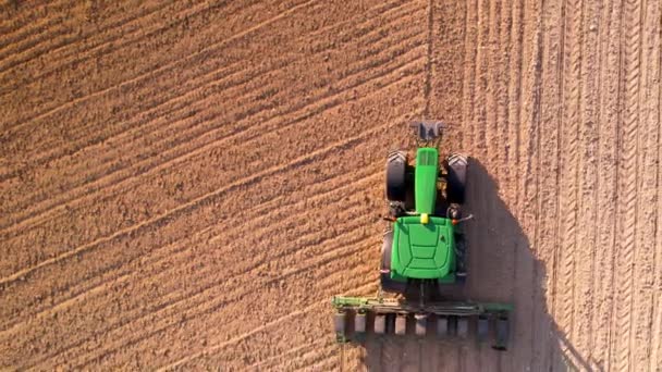 Vista aérea del tractor con sembradora montada que realiza la siembra directa de cultivos en el campo agrícola arado. Agricultor está utilizando maquinaria agrícola para el proceso de plantación, vista superior — Vídeo de stock