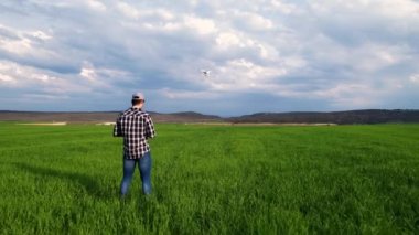 Genç çiftçi bir tarlanın üzerinde dron uçuruyor. Yüksek kalite 4k görüntü
