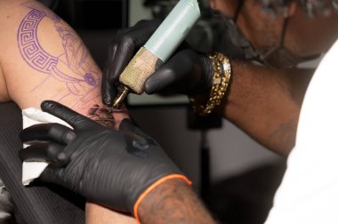 Dövme sürecini kapat. Usta profesyonel dövme makinesiyle hatlar çiziyor. Yüksek kaliteli fotoğrafçılık
