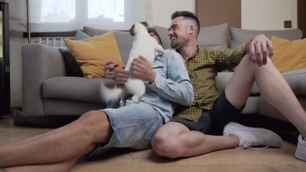 Happy Gay Couple Sitting Floor Playing Dog Home High Quality — 图库视频影像