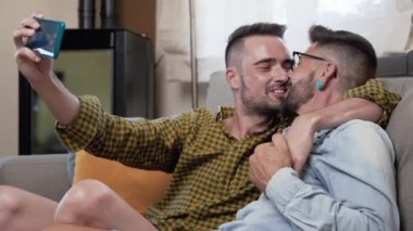 Young smiling gay couple taking selfie at home. High quality 4k footage