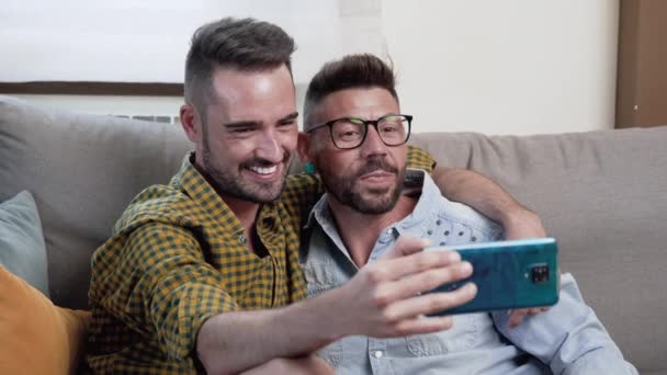 Gay Couple Sitting Sofa Home Making Video Call Mobile Phone — Stock Video