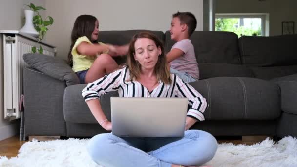 Irritated Mother Sits Carpet Works Home Laptop Naughty Active Children — Stockvideo