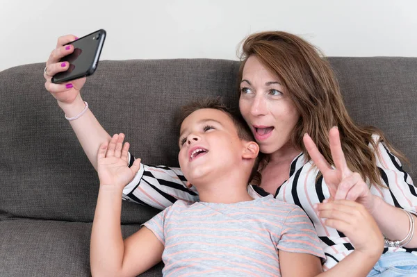 Cheerful Mother Holding Smart Phone Making Selfie Her Little Son — ストック写真