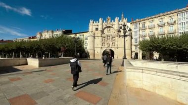 Burgos, İspanya - 18 Ekim 2022. Santa Maria kemerinden ve Burgos, İspanya 'daki ortaçağ köprüsünden geçen turistler. Yüksek kalite 4k görüntü