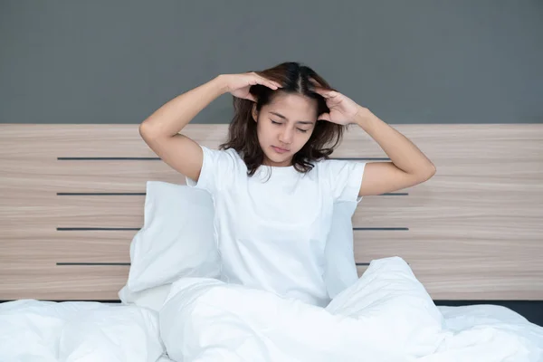 若いですアジアの女性はベッドの上で彼女の頭を保持して横たわっている強力な頭痛多分ベッドの上で午前中に偏頭痛 — ストック写真
