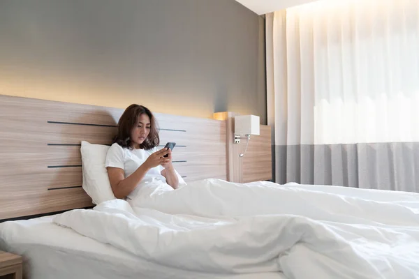 Wanita Asia Muda Berbaring Tempat Tidur Sms Dan Memeriksa Aplikasi Stok Gambar