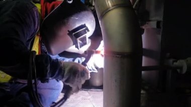 Professional Welder Wears Helmet Working in Heavy Industry Process Pipe, Welding Piping Construction of the Oil, Natural Gas and Fuels Transport Pipeline. Industrial Manufacturing Factory.