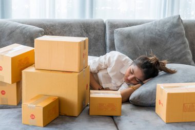 Güzel Asyalı kadınlar kanepelerde uyurlar. Küçük işletmeleri olan bir sürü paket kutuyla. Müşterilere internet üzerinden satış yaparlar..